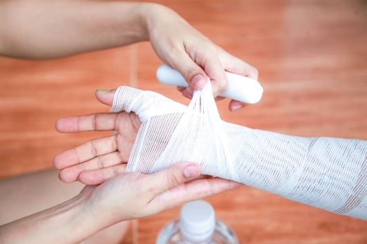 burn injury on forearm being wrapped in gauze
